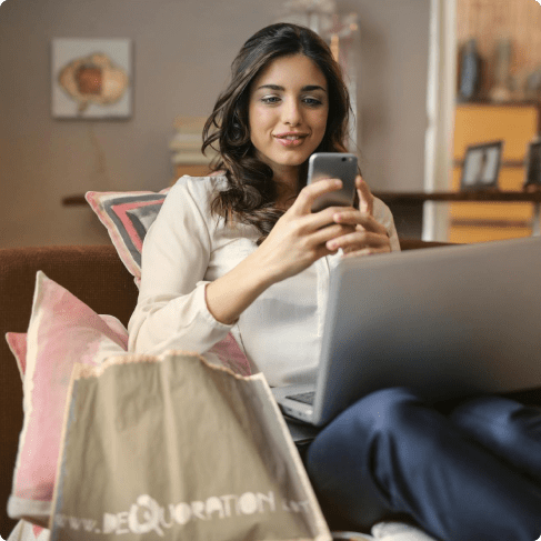 Woman using phone and laptop