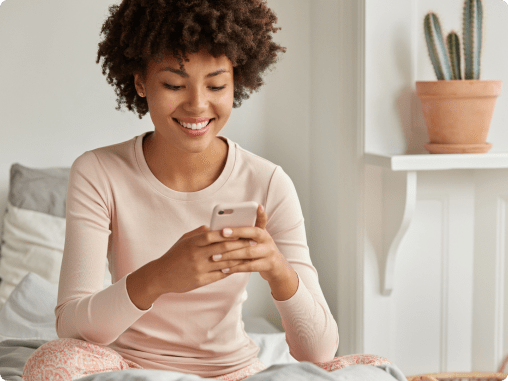 Positive black lady with afro haircut using a smartphone, representing modern approaches to couples therapy