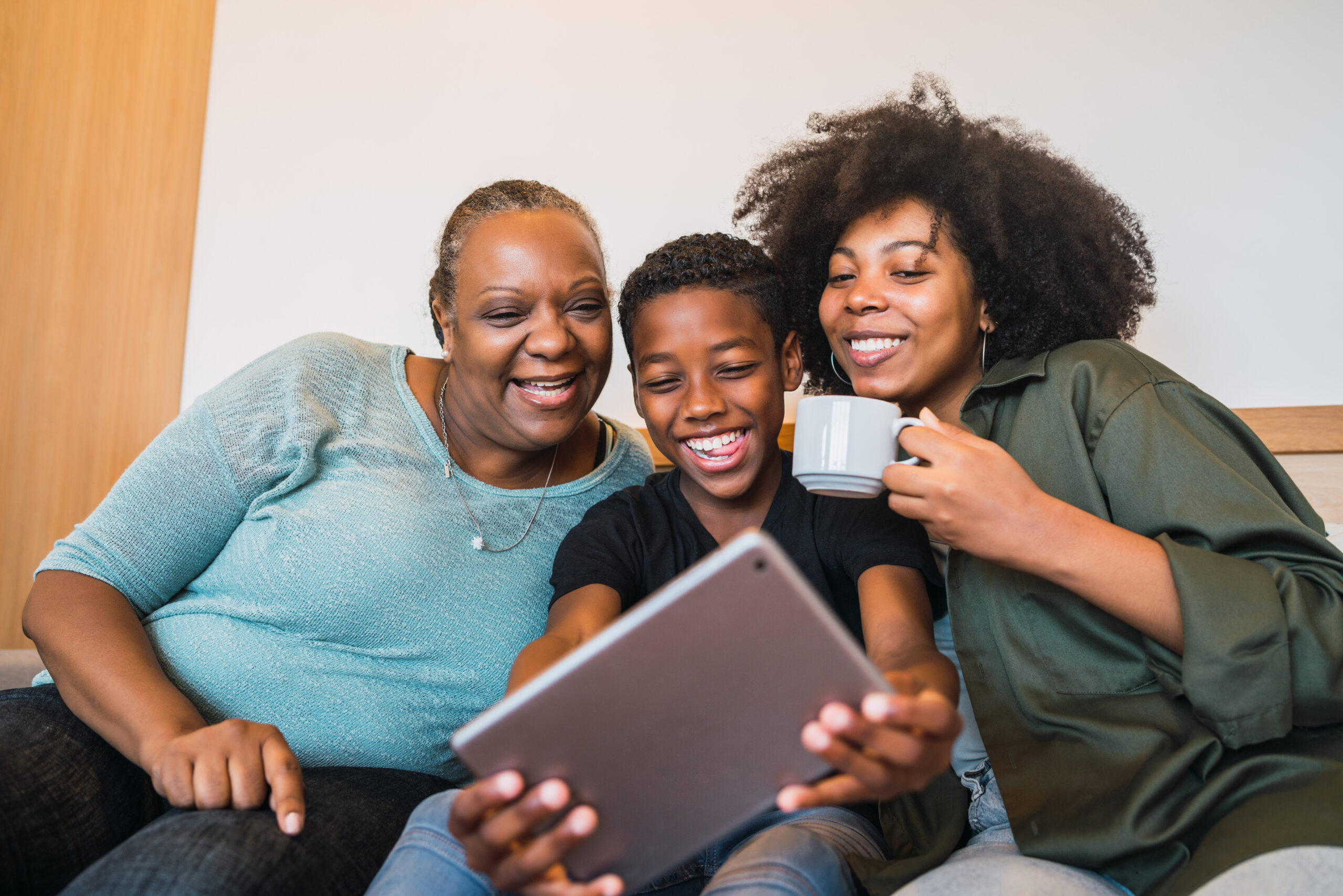 portrait-african-american-grandmother-mother-son-taking-selfie-with-digital-tablet-home-scaled